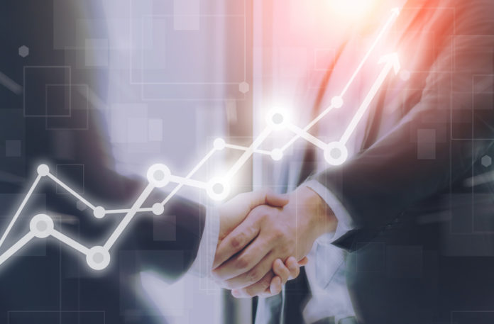 Businessman making handshake with a businesswoman on futuristic technology connection shape motion blur background with graph and chart rise up.Greeting and dealing business success concepts.