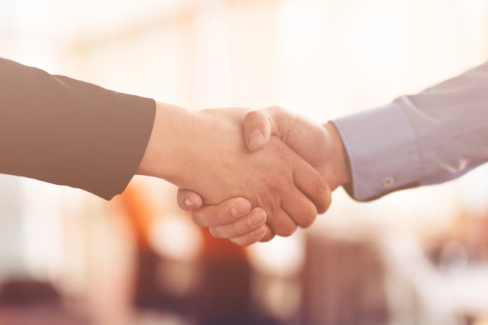 People at work: man and woman hand shaking at a meeting