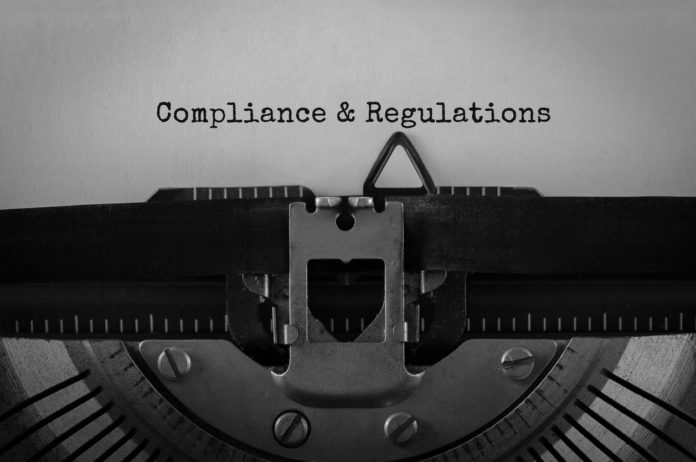 Text Compliance and Regulations typed on retro typewriter
