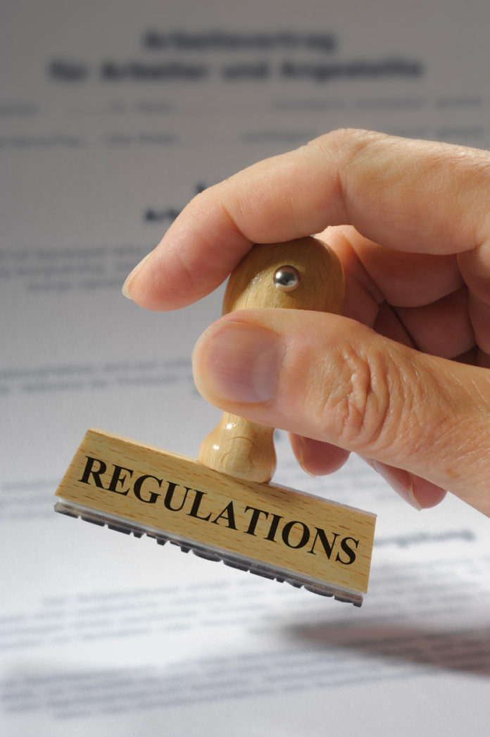 regulations printed on rubber stamp in hand