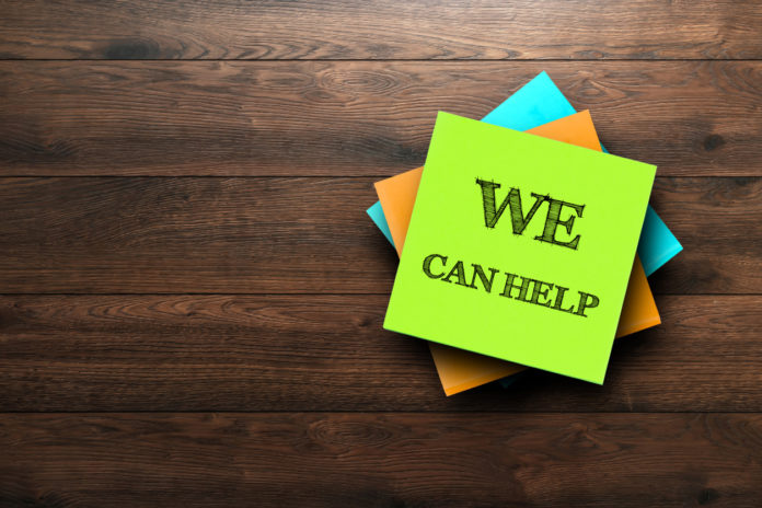 We Can Help, the phrase is written on multi-colored stickers, on a brown wooden background. Business concept, strategy, plan, planning.