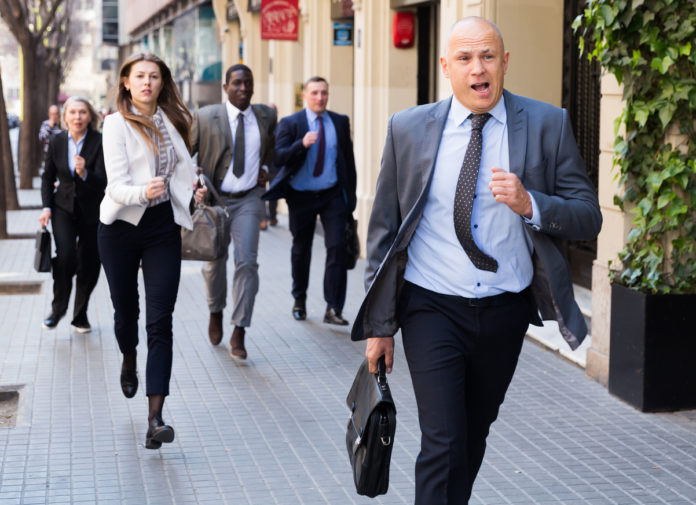 Hurrying people with stressed man in foreground