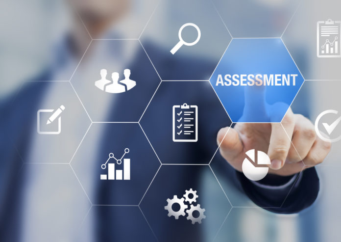 Assessment and analysis by professional auditing consultant concept, person touching screen with icons of risk evaluation, business analytics, quality compliance, process inspection, financial audit