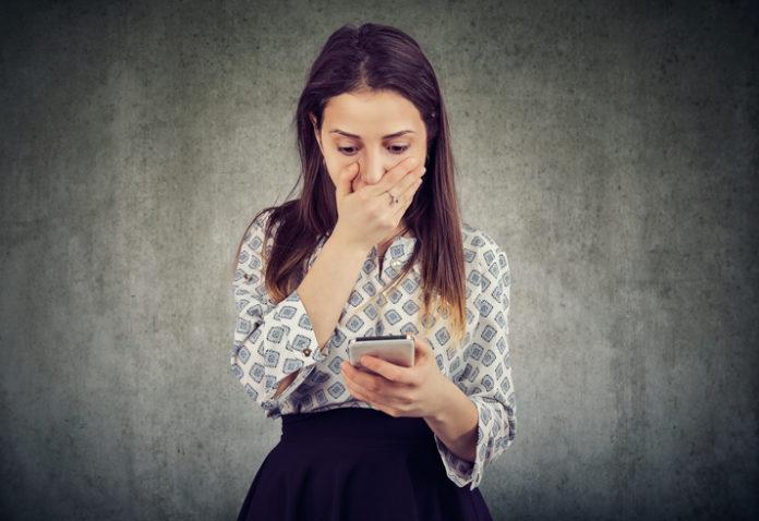 Shocked girl reading smartphone