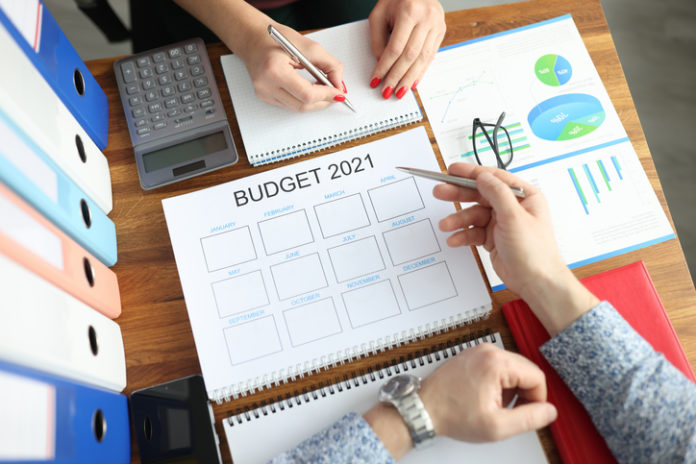 Business man and woman with pens in hands showing charts on document at table in office closeup