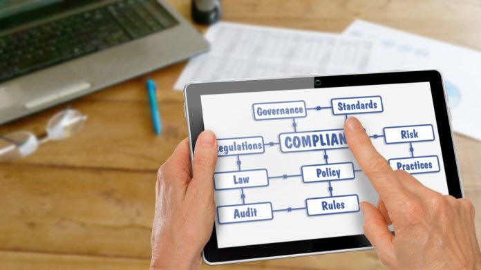 Tablet with Hands Researching Compliance