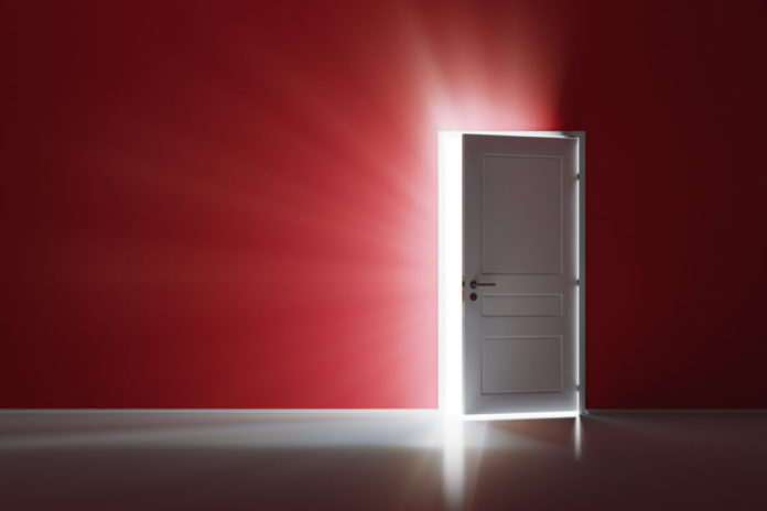 Open white door on red wall
