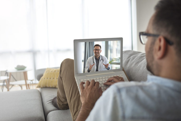 Man using laptop and having video call with his doctor