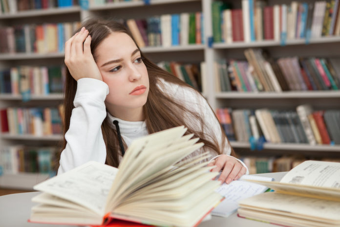 Teen girl studying at the library