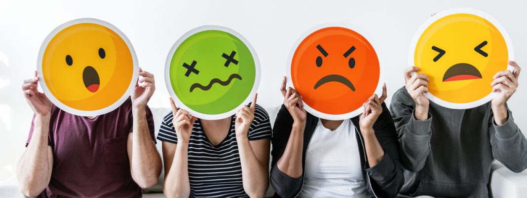 Diverse people holding emoticon